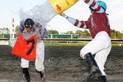 Jockey Paco Lopez (L) gets a cooler of ice water dumped on him by Jockey Gabriel Saez after Lopez scored a Monmouth Park record 7th win in a day in the last race at the Oceanport, New Jersey track aboard Tycoon Cat on Saturday May 17, 2014. Photo By William Osborn/EQUI-PHOTO